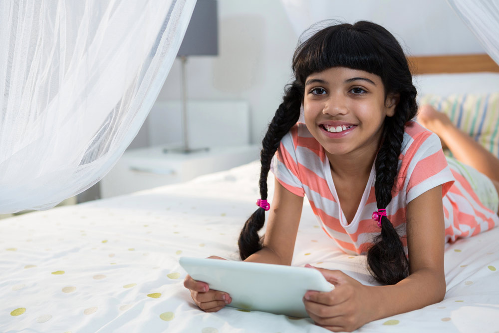 Young girl playing games on mobile tablet